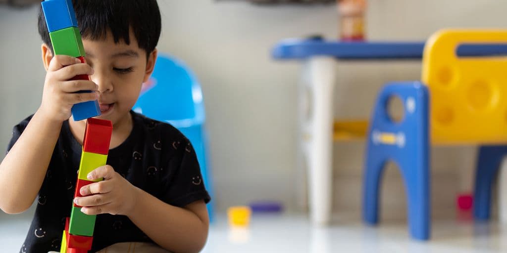 a young boy plays with blocks