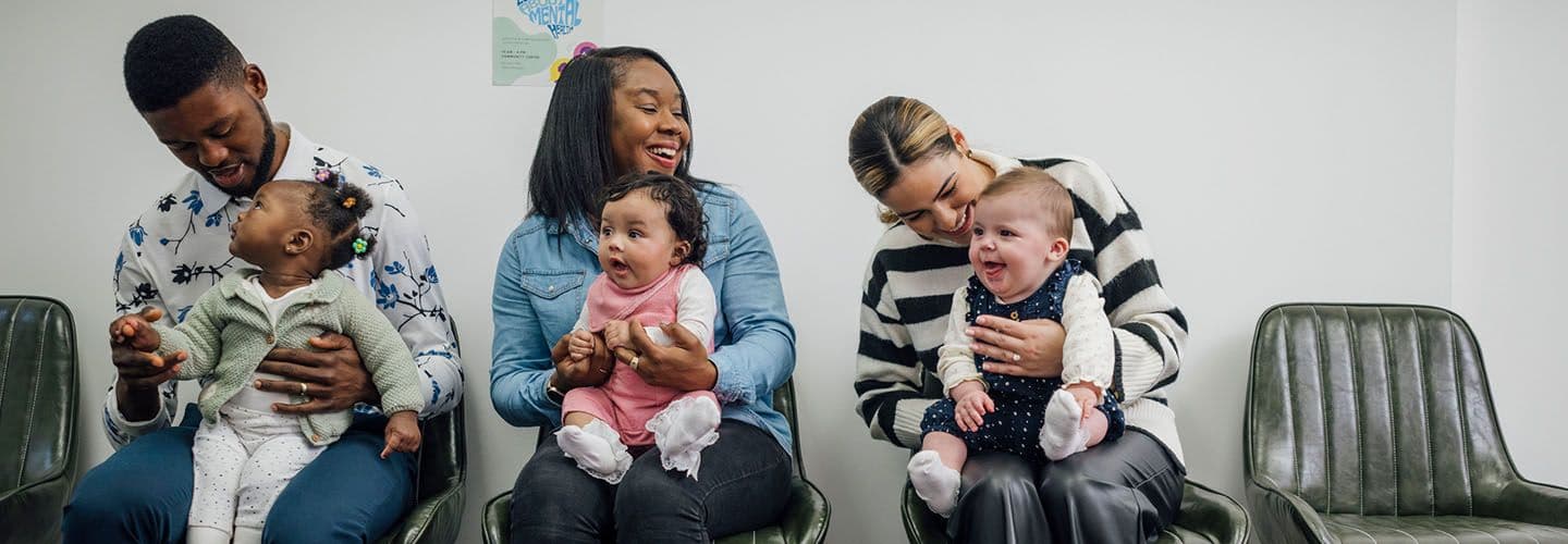parents and babies sit in a waiting room