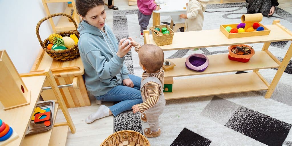 a young woman and toddler play with toys
