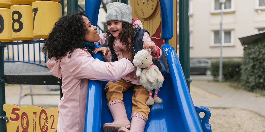 mother and daughter on slide at playground
