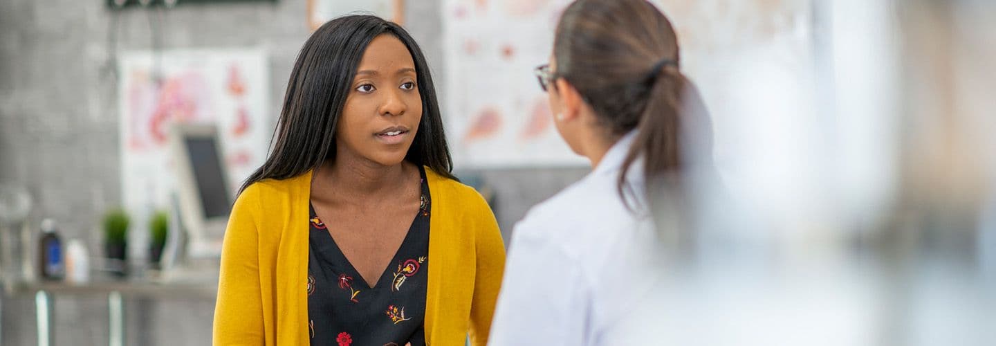 a young woman talks to her doctor