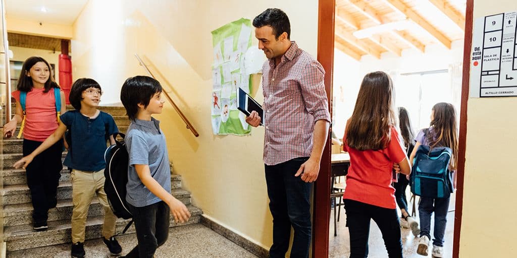 a teacher welcomes students to class