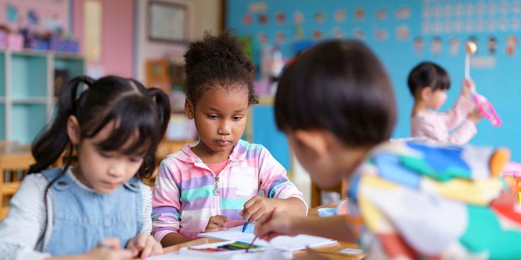 young children play at a table in daycare