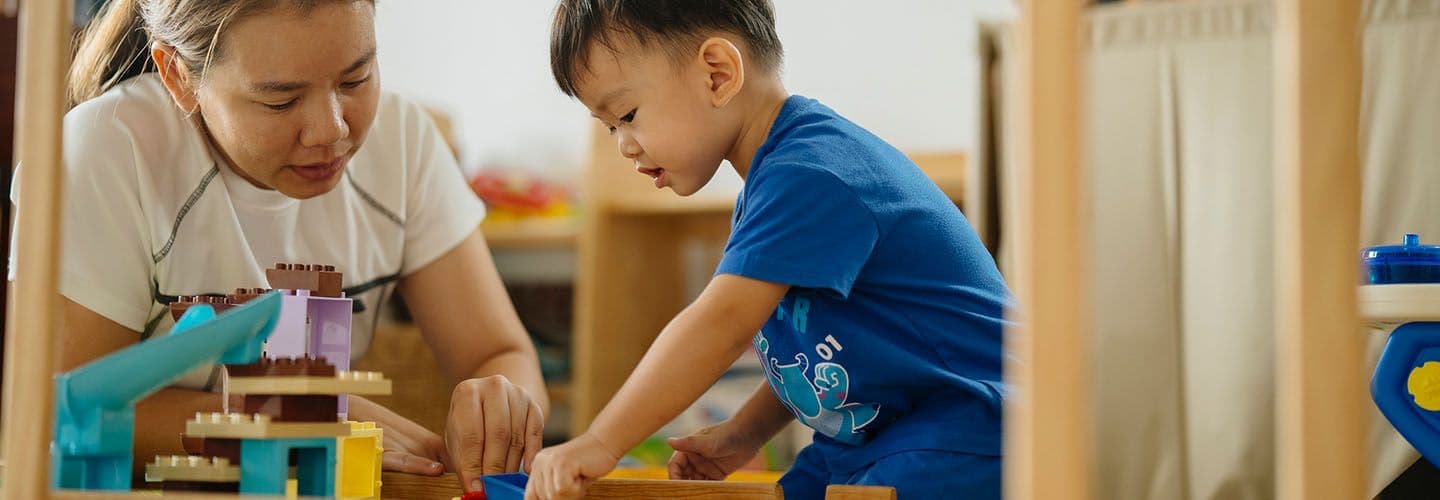 a young boy and his mom play with blocks