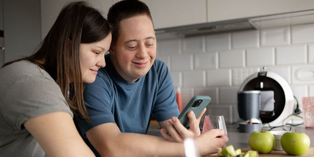 a young couple with down syndrome hang out in the kitchen