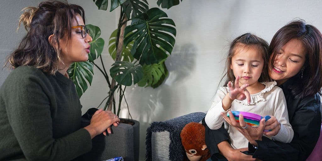 a doctor observes a young girl with her mother