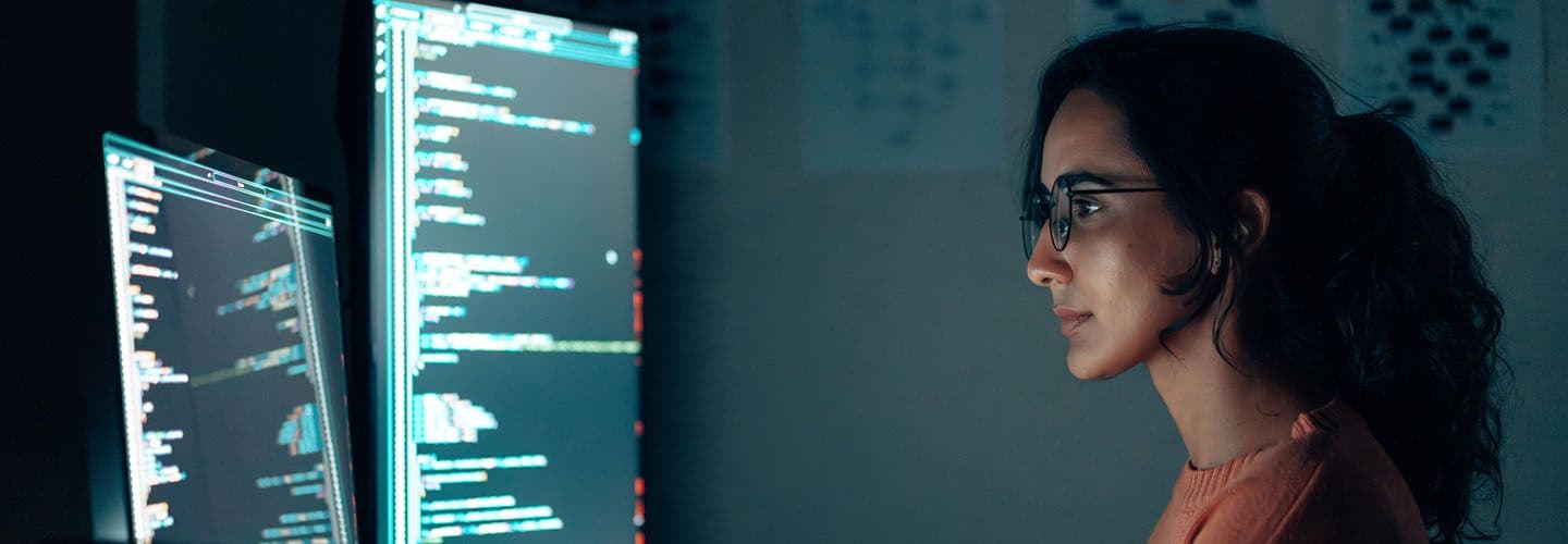 a young woman works on computer code