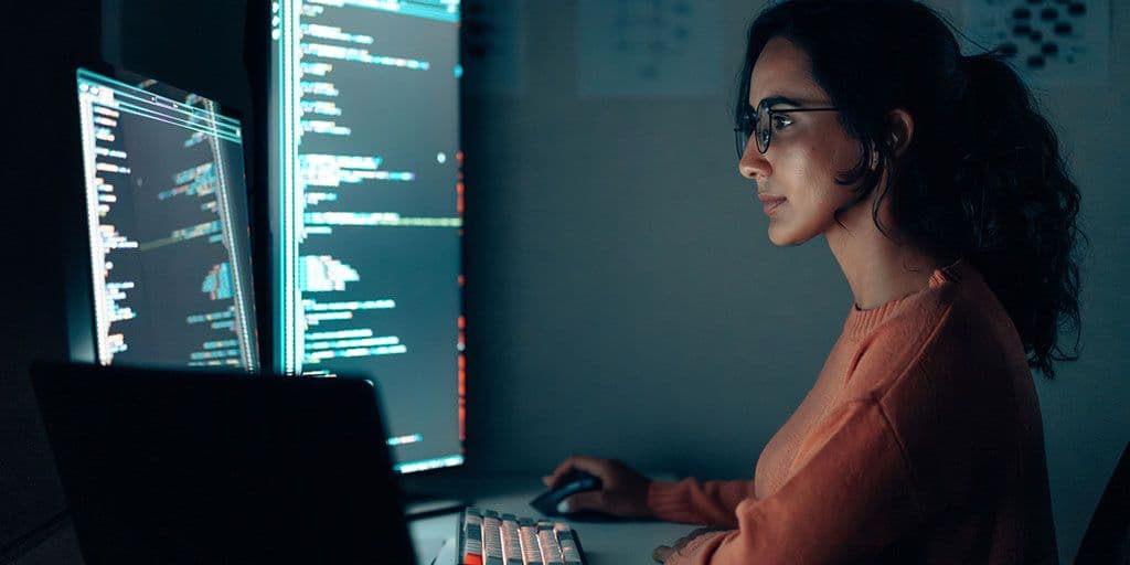 a young woman works on computer code