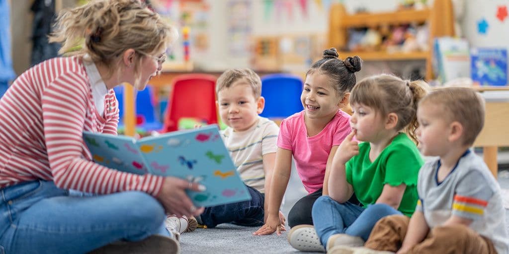 a teacher reads a storybook to young children