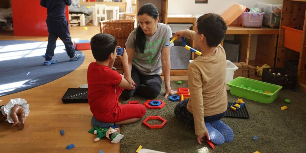 a teacher plays with children at daycare